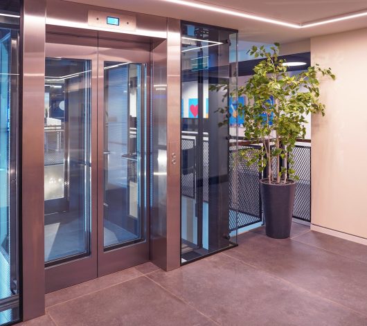 Glass elevator doors in office building. Wide angle view of modern elevators with doors. Elevators in business centre or modern floor